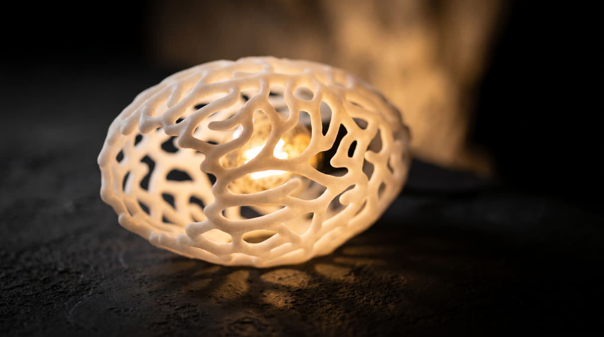 Luminaria orgánica impresa en 3D con estructura tipo coral, iluminada por dentro
